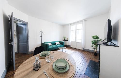 uma sala de estar com uma mesa e um sofá verde em Affaire et séjour appart tout confort, à 250 m de la gare, hyper centre em Tours