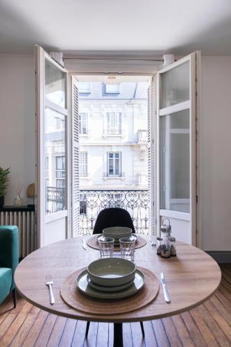 - une table avec des assiettes dans une chambre avec des fenêtres dans l'établissement Appartement avec balcon à 250 m de la gare, hyper centre, à Tours