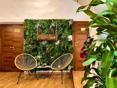 a lobby with two chairs and a green wall at CANTU' SUITE in Catania