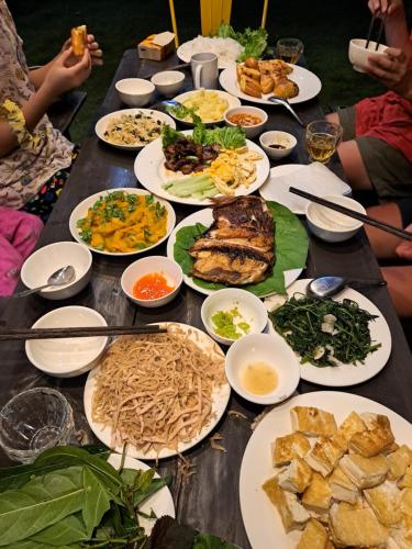 a long table with plates of food on it at Homestay field - bungalow, Ha giang loop tour, motorbikes rental in Ha Giang