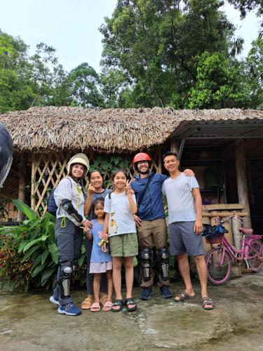 a group of people standing in front of a house at Homestay field - bungalow, Ha giang loop tour, motorbikes rental in Ha Giang