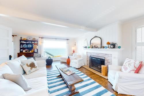 a living room with white furniture and a fireplace at Sea Cliff Cottage in Lincoln City