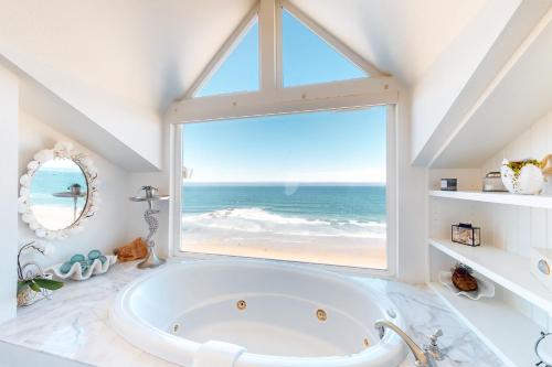 a bath tub in a bathroom with a large window at Sea Cliff Cottage in Lincoln City