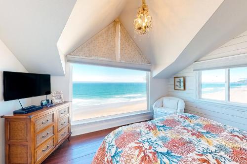 a bedroom with a bed and a large window with the ocean at Sea Cliff Cottage in Lincoln City