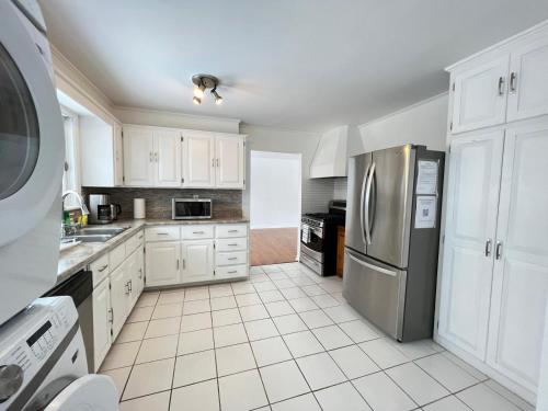 a kitchen with white cabinets and a stainless steel refrigerator at Letitia Heights !E Spacious and Quiet Private Bedroom with Private Bathroom in Barrie