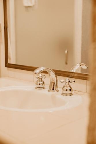 a bathroom sink with two faucets and a mirror at Hotel Casa Pereyra in Oaxaca City
