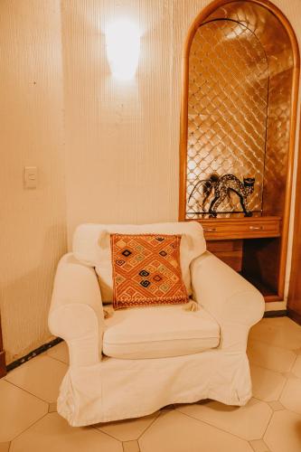 a white couch sitting in a room with a mirror at Hotel Casa Pereyra in Oaxaca City