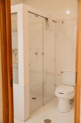 a bathroom with a toilet and a glass shower at Hotel Casa Pereyra in Oaxaca City