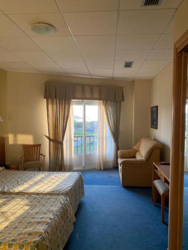 ein Hotelzimmer mit einem Bett, einem Stuhl und einem Fenster in der Unterkunft Hotel Agrelo in Reboredo