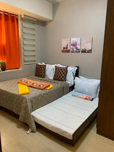 - deux lits assis l'un à côté de l'autre dans une pièce dans l'établissement One Bedroom Unit across NAIA Terminal 3 Airport, à Manille