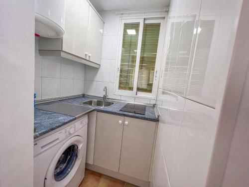 cocina con lavadora y fregadero en BeniSol tu hogar en Benidorm en Benidorm
