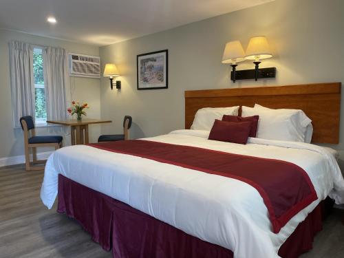 a hotel room with a large bed and a table at The Cutty Sark in Dennis Port