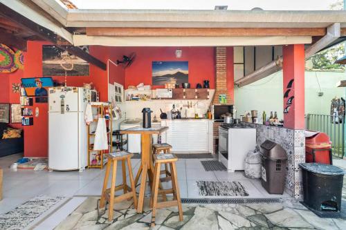 a kitchen with white appliances and red walls at Guest House Vida Vibra in Ubatuba