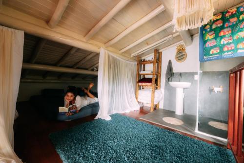 Eine Frau, die auf einer Couch in einem Zimmer liegt. in der Unterkunft Casinha Azul Caraíva - casa completa na beira do Rio in Caraíva