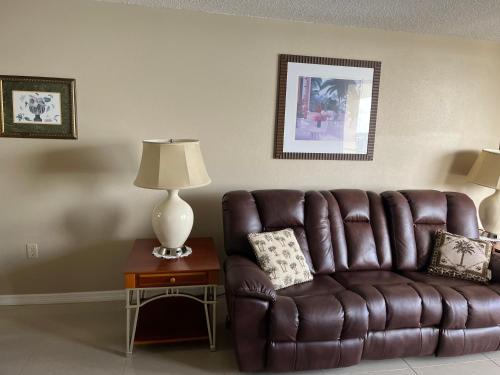 un sofá de cuero marrón en una sala de estar con lámpara en Cozy Gulf of Mexico Resort Condo #603 in Hudson en Hudson