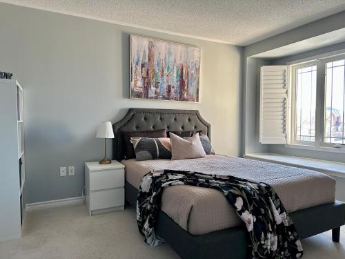a bedroom with a bed with a painting above it at Cozy 5 Bedroom House Mississauga in Mississauga
