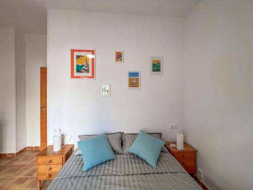 a bedroom with a bed with two blue pillows at BeniSol tu hogar en Benidorm in Benidorm
