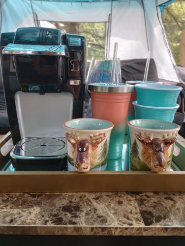 ein Tablett mit Tassen Essen auf einem Tisch in einem Zelt in der Unterkunft Glamping on the Green River in Washago