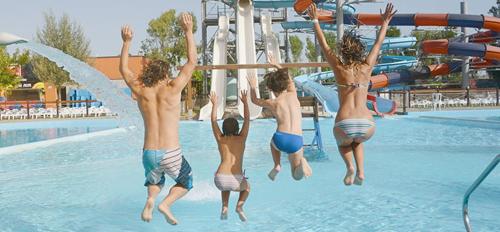 a group of men jumping into a swimming pool at Attico al mare Zoomarine a 40 minuti da Roma in Torvaianica