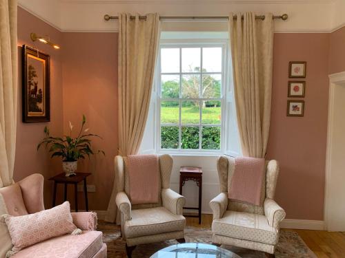 a living room with two chairs and a window at The Nurseries in Boyle