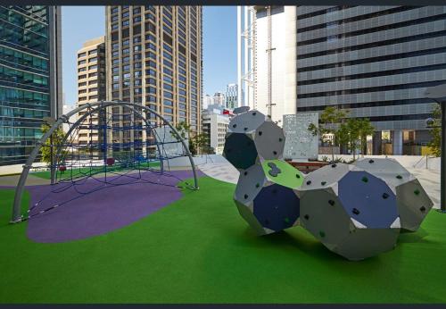 a playground in a city with a swing at Brisbane Riverfront Oasis 2Bed Panoramic RiverView in Brisbane
