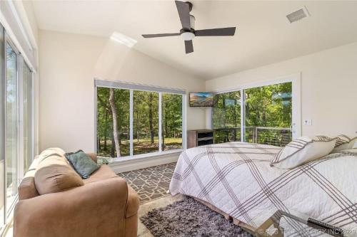 a bedroom with a bed and a couch and windows at SummerHill Ranch at Grand Lake 8bed/10bath in Grove