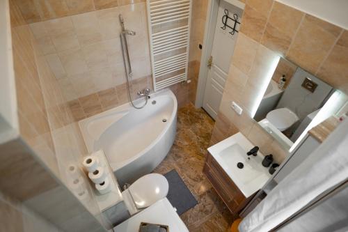 a bathroom with a tub and a toilet and a sink at Vila Antonio in Prague