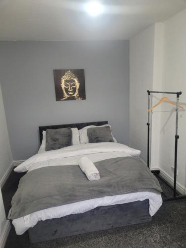 1 dormitorio con 1 cama grande con máscara en la pared en Decent Homes No 4- modern double room en Dukinfield