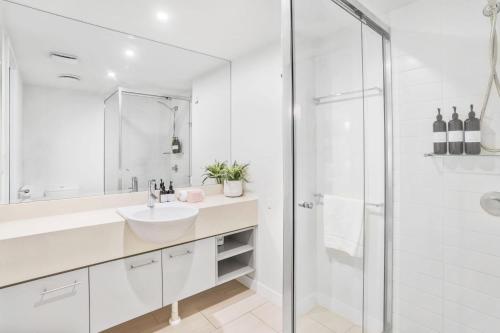 a white bathroom with a sink and a shower at Hotel Drift 3205 in Palm Cove