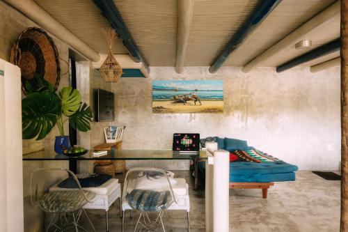 ein Wohnzimmer mit einem blauen Sofa und einem Schreibtisch in der Unterkunft Casinha Azul Caraíva - casa completa na beira do Rio in Caraíva