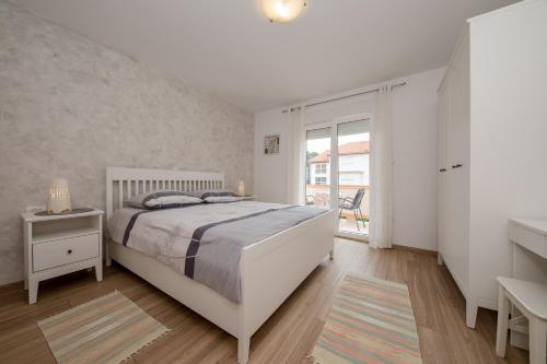 ラブにあるApartments with parking space Palit, Rab - 4970のベッドと窓のある白い寝室