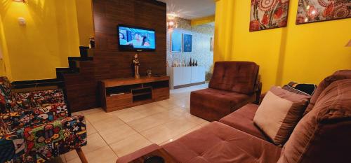 a living room with a couch and a flat screen tv at Canto da Lua in Lençóis