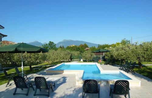 a swimming pool with chairs and an umbrella at Villa Torri in Torano Nuovo