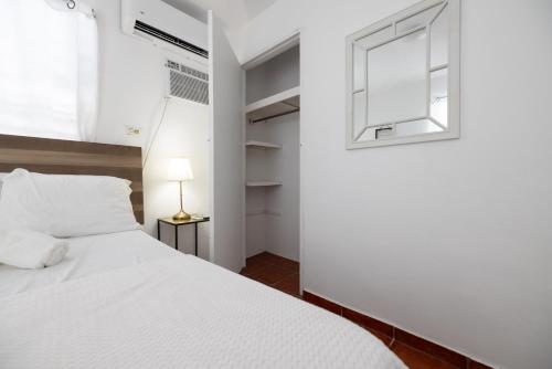 a bedroom with a white bed and a window at R&V Combate Beach House 1 with Pool in Cabo Rojo