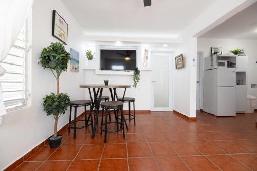 a living room with a table and some stools at R&V Combate Beach House 1 with Pool in Cabo Rojo