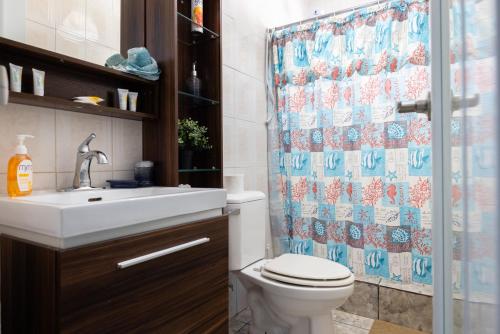 a bathroom with a toilet and a shower curtain at R&V Combate Beach House, 2nd Floor with Pool in Cabo Rojo