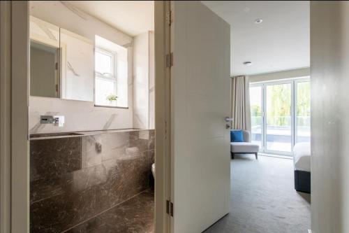 ein Bad mit einem Waschbecken und einem Spiegel in der Unterkunft 2BD, 2BA Urban Oasis CHCL F4 in Chigwell