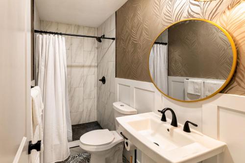 Baño blanco con lavabo y espejo en Newly Renovated Studio on First Floor in Quiet Complex Across the Street from the Beach, en Kihei