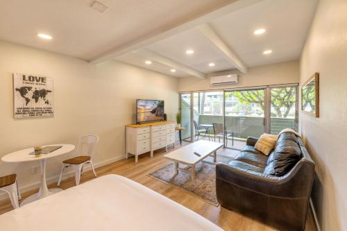 a living room with a couch and a table at Newly Renovated Studio on First Floor in Quiet Complex Across the Street from the Beach in Kihei