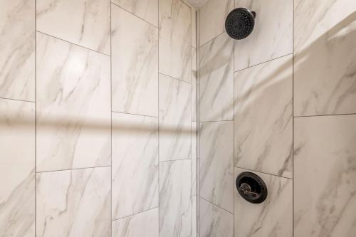 a bathroom with a shower with white marble tiles at 3mins Walk to Beach! Laundry, Pool, Hot Tub & More in Kihei