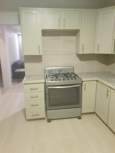 a kitchen with a stove and white cabinets at classical accommodation. in Gwa Kay
