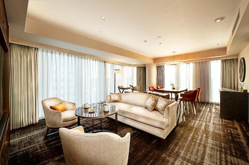 a living room with a couch and chairs and a table at Hotel GrandBach Sendai in Sendai