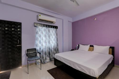 a bedroom with a bed and a chair and a window at Super OYO The Suncity Hotel in Patna