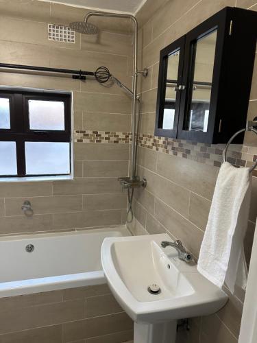 a bathroom with a sink and a bath tub at Kaya Apartments in Lusaka