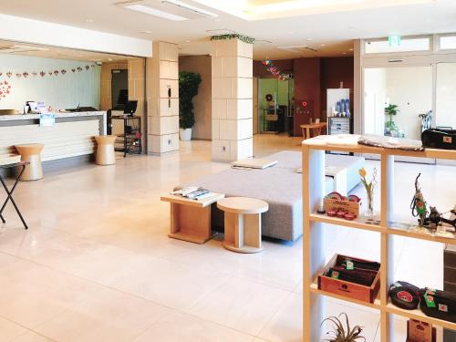 a large room with a lobby with tables and chairs at Tabino Hotel Kurashiki Mizushima in Kurashiki