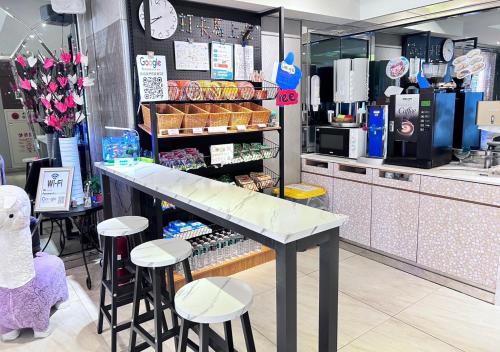 HopeCity MinSheng Hotel في تايبيه: كونتر في متجر مع المقاعد و سيد منضدة