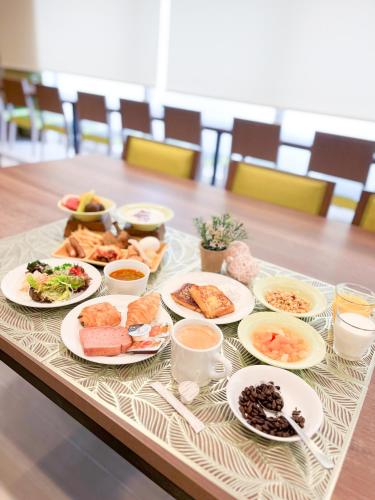 a table with plates of food on top of it at Tabino Hotel Kurashiki Mizushima in Kurashiki