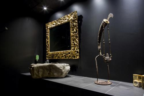 a exhibit with a shower and a rock and a mirror at Aux Terrasses in Tournus