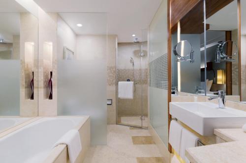 a bathroom with a tub and a sink and a shower at Swissôtel Grand Shanghai in Shanghai