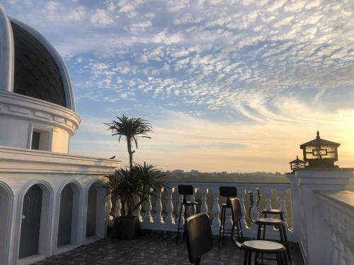a balcony with chairs and a view of the water at Hotel Hoa Nắng in Bao Loc